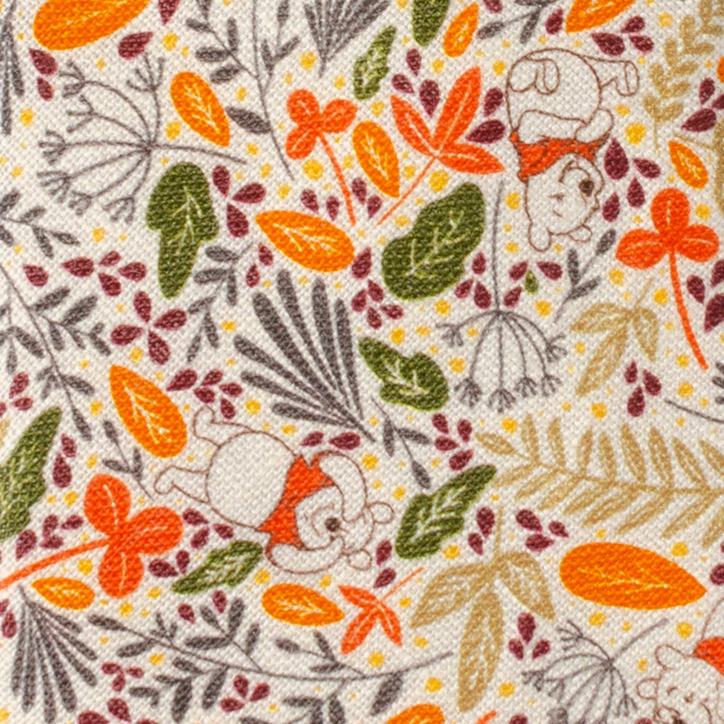 Close-up of tan patterned tie fabric with Winnie the Pooh, orange flowers, and greenery