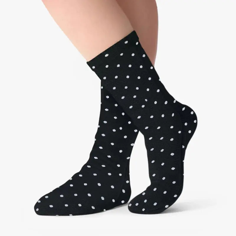 Black fleece socks with white polka dots, on-foot view