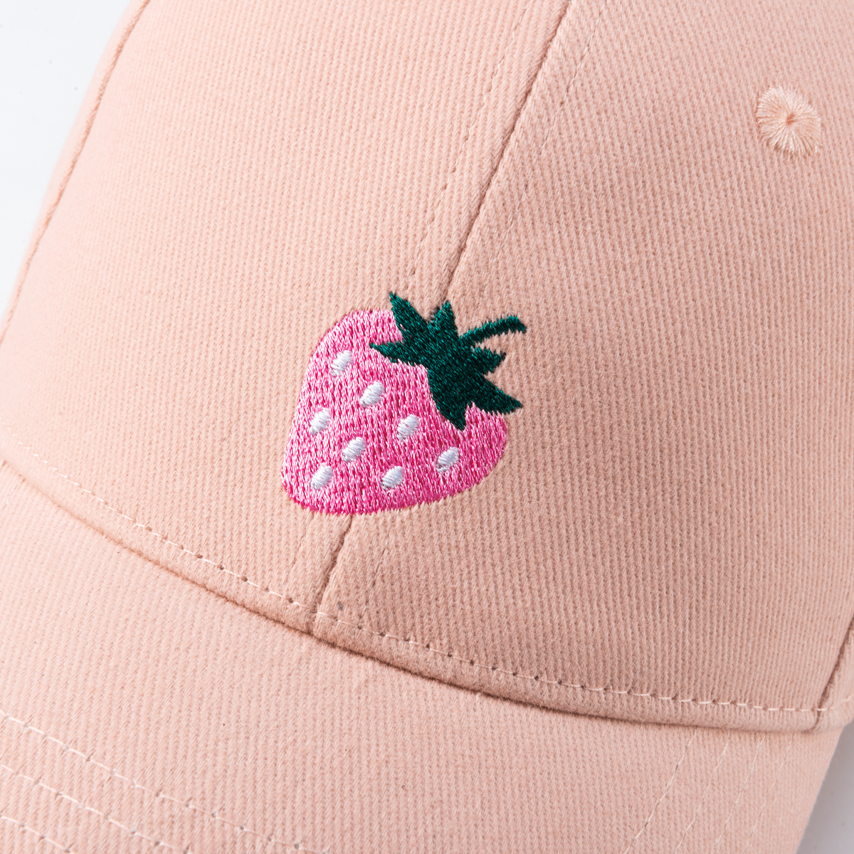 Pastel pink cap with embroidered strawberry patch on the front panel