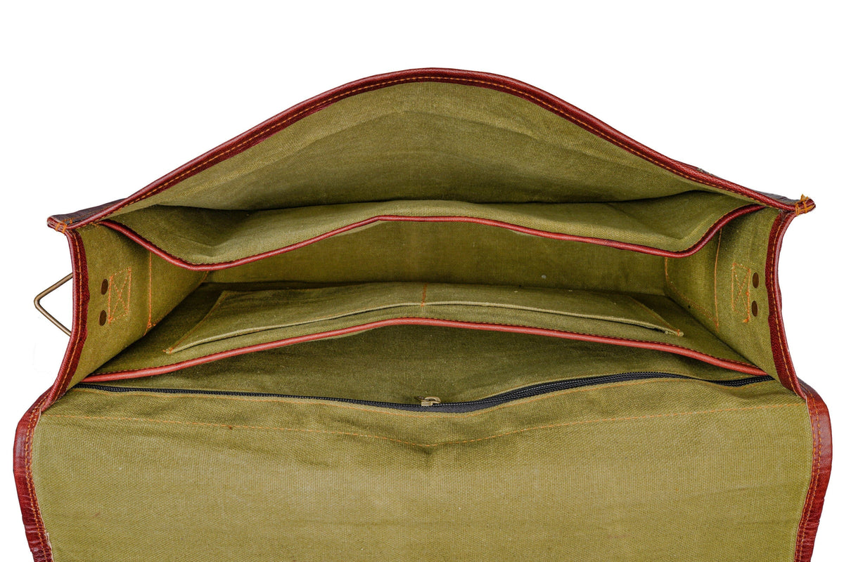 Open brown leather briefcase showing green fabric lining and interior compartments
