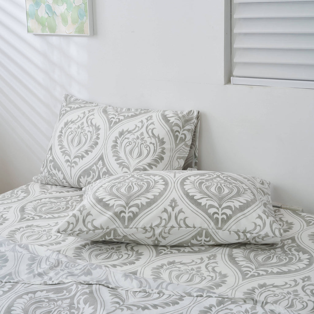 Gray and white damask ogee-pattern pillowcase on bed with matching pillow