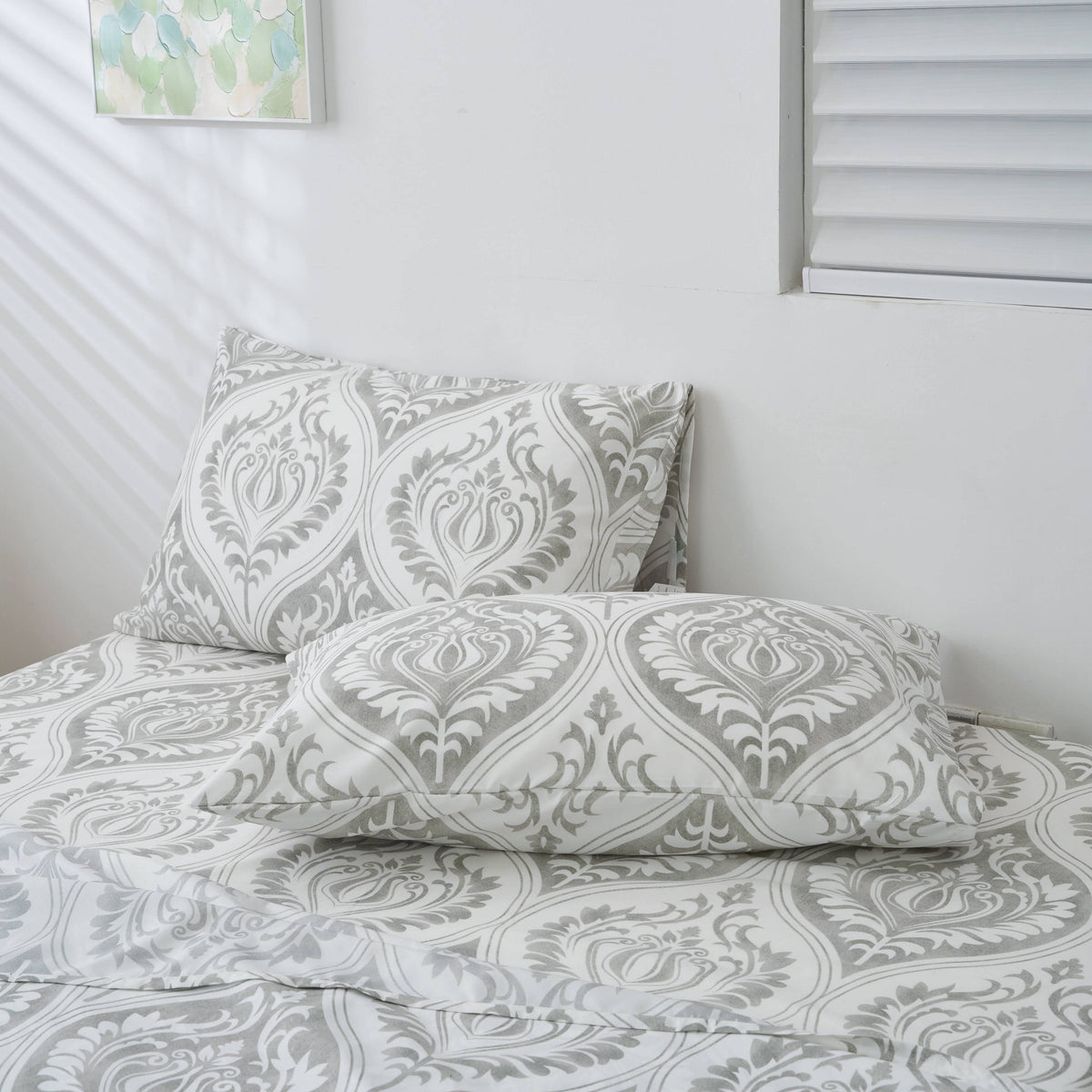 Gray and white damask ogee-pattern pillowcase on bed with matching pillow