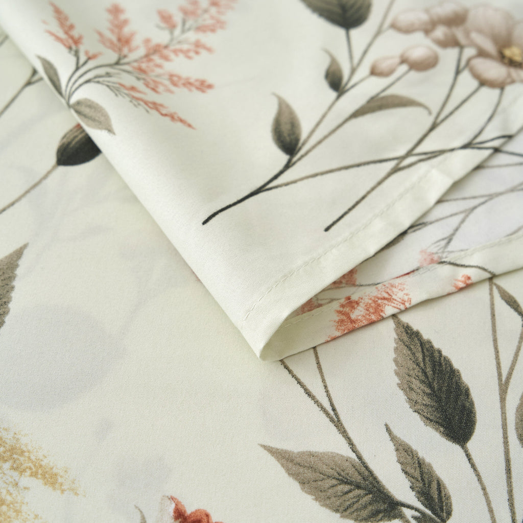 Folded floral microfiber sheet fabric in cream with detailed leaves and orange accents
