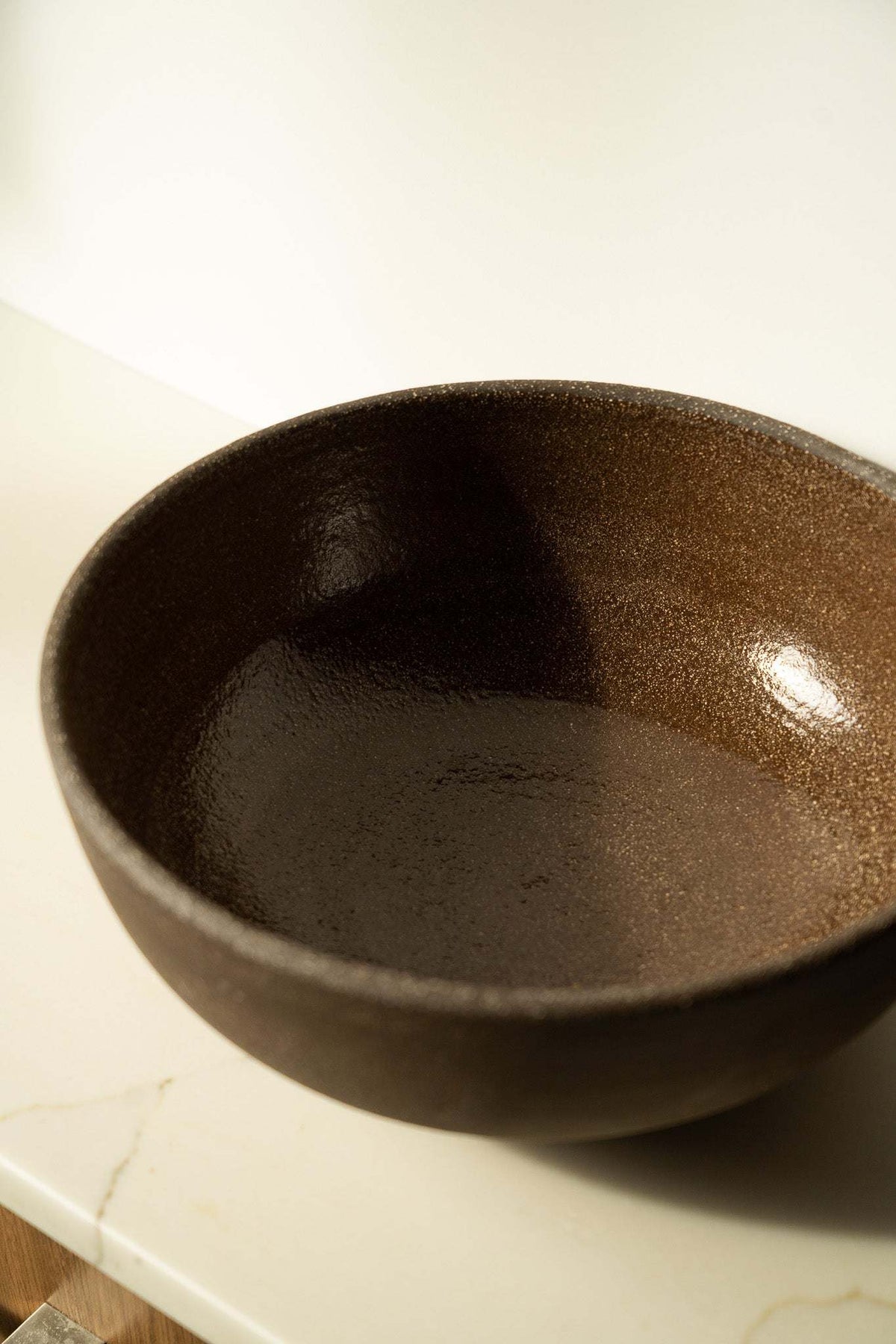Stoneware fruit bowl, dark brown speckled glaze, wide rim and shallow bowl.