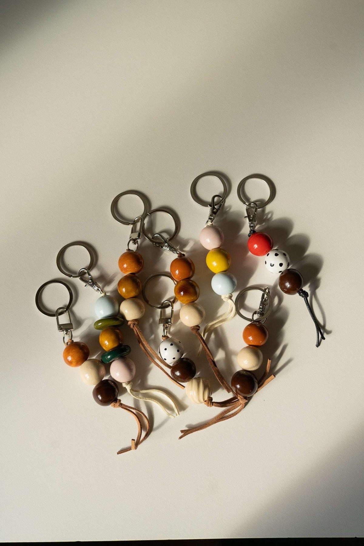 Group of ceramic keychains with multicolor beads, metal keyrings, and tassel charms
