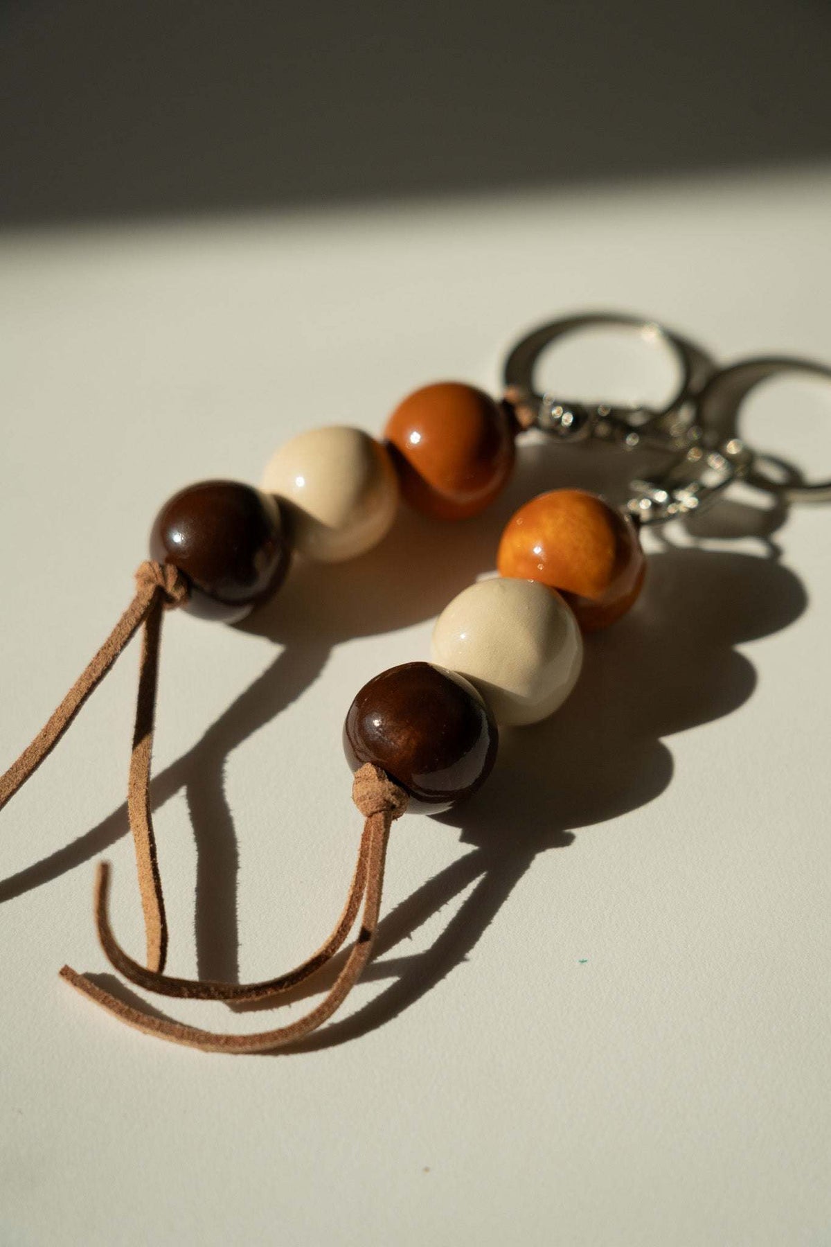 Close-up handmade ceramic keychain beads with tassel and metal keyring