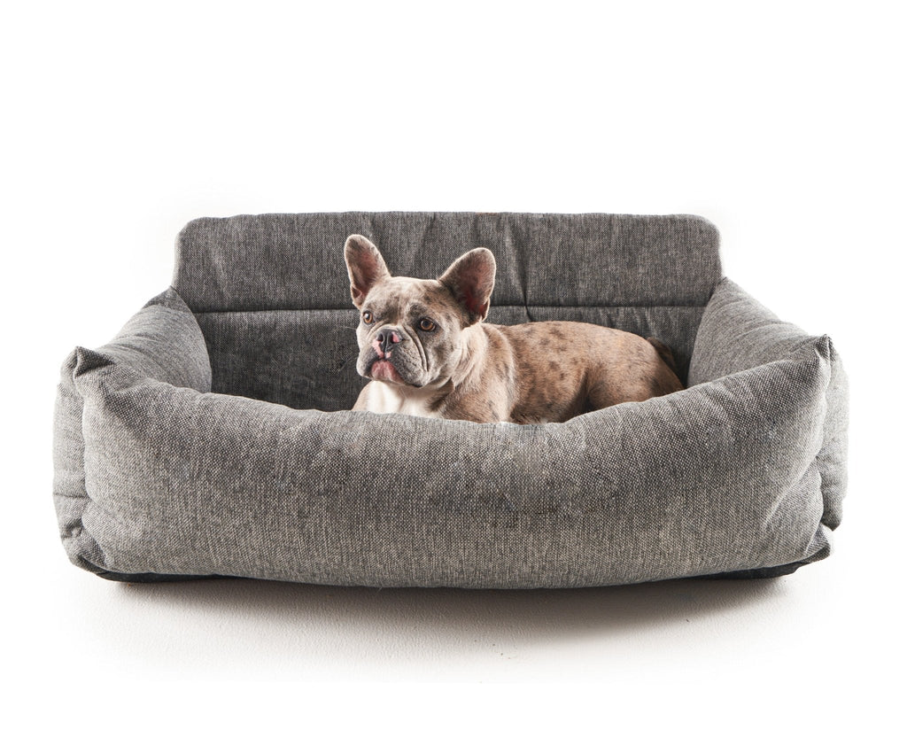 Gray dog car bed with thick padded sides; dog curled inside.