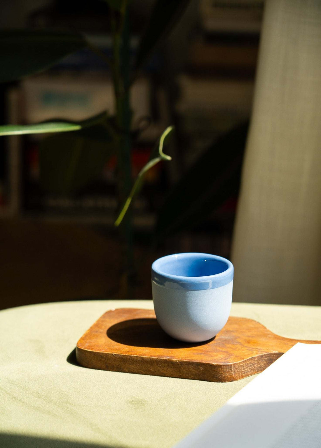 Handmade blue porcelain espresso cup on a wooden saucer tray