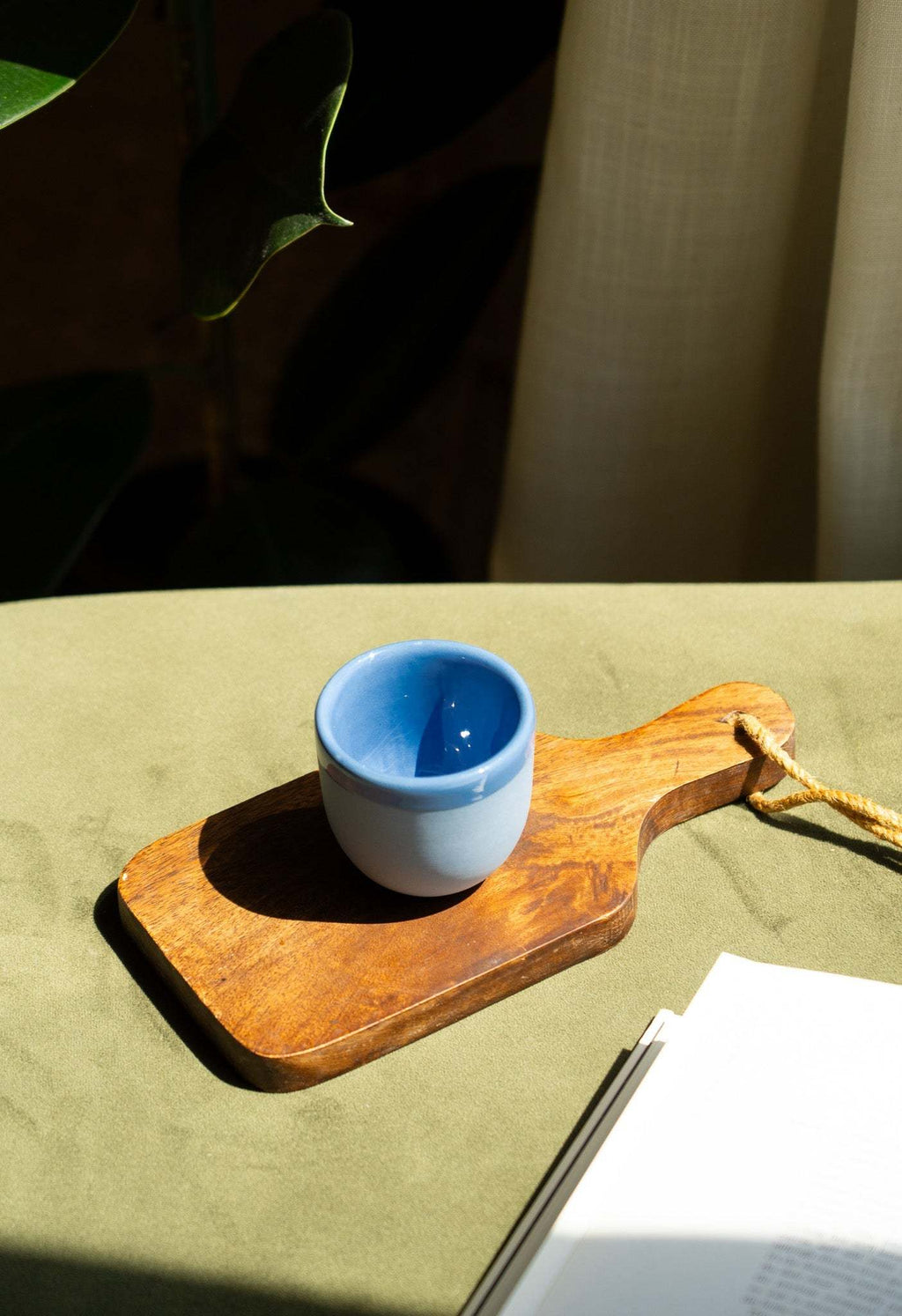 Handmade blue porcelain espresso cup on a wooden saucer tray