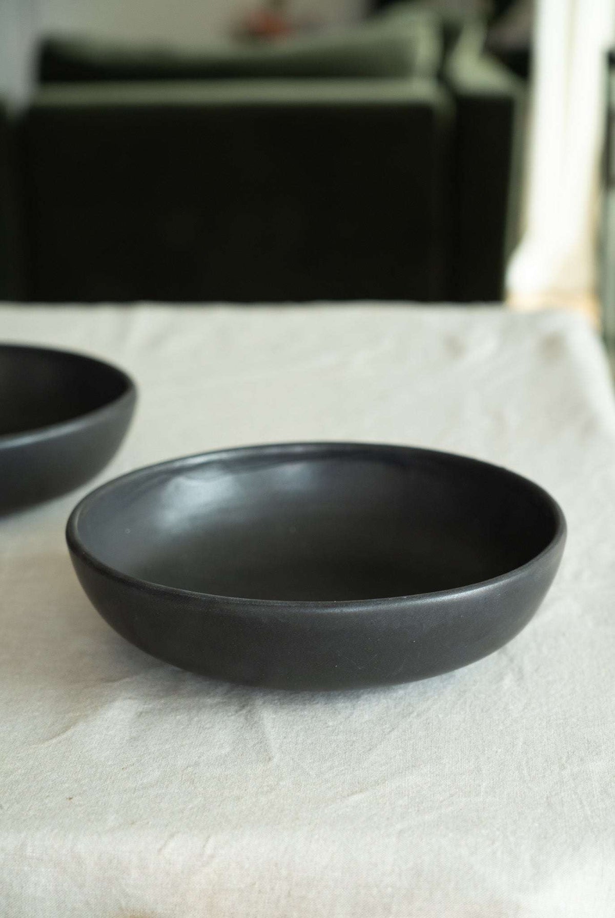 Black matte stoneware pasta bowl, empty, low side angle