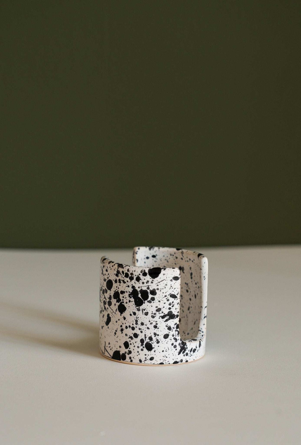 Ceramic sponge holder cup with speckled black-and-white splatter pattern