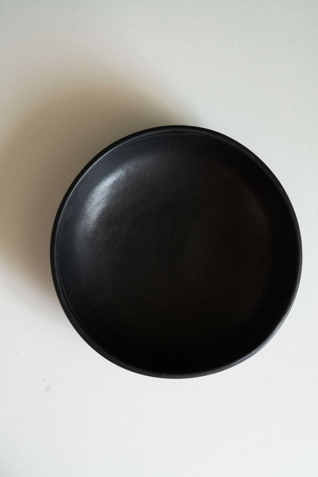 Round black matte stoneware pasta bowl, top view, empty