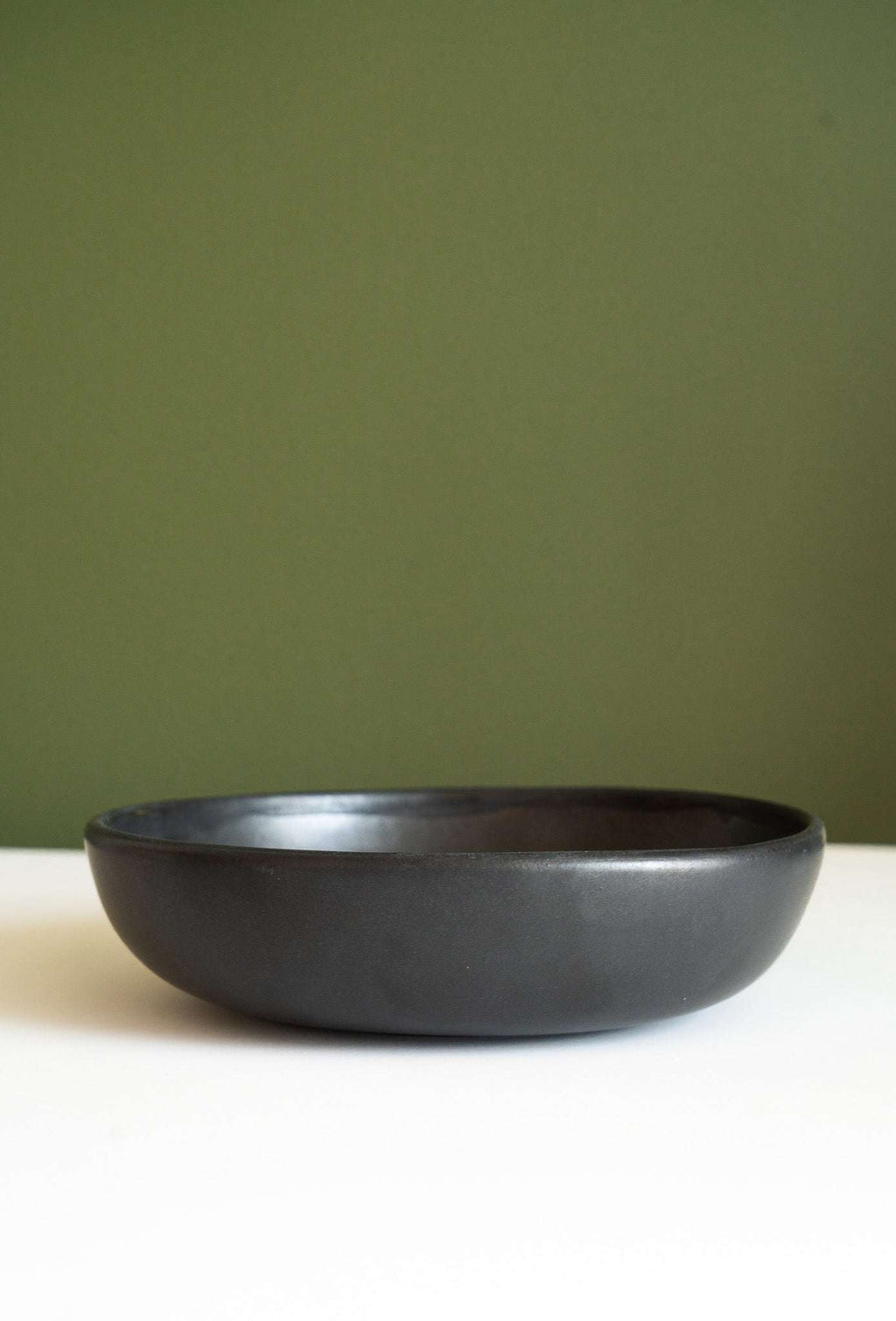 Black matte stoneware pasta bowl, empty, side view