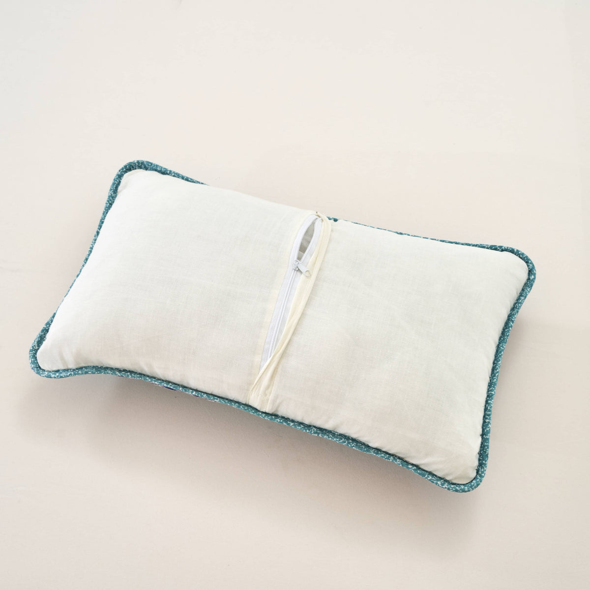 Turquoise-edged lumbar pillow sham with white backing and hidden zipper closure