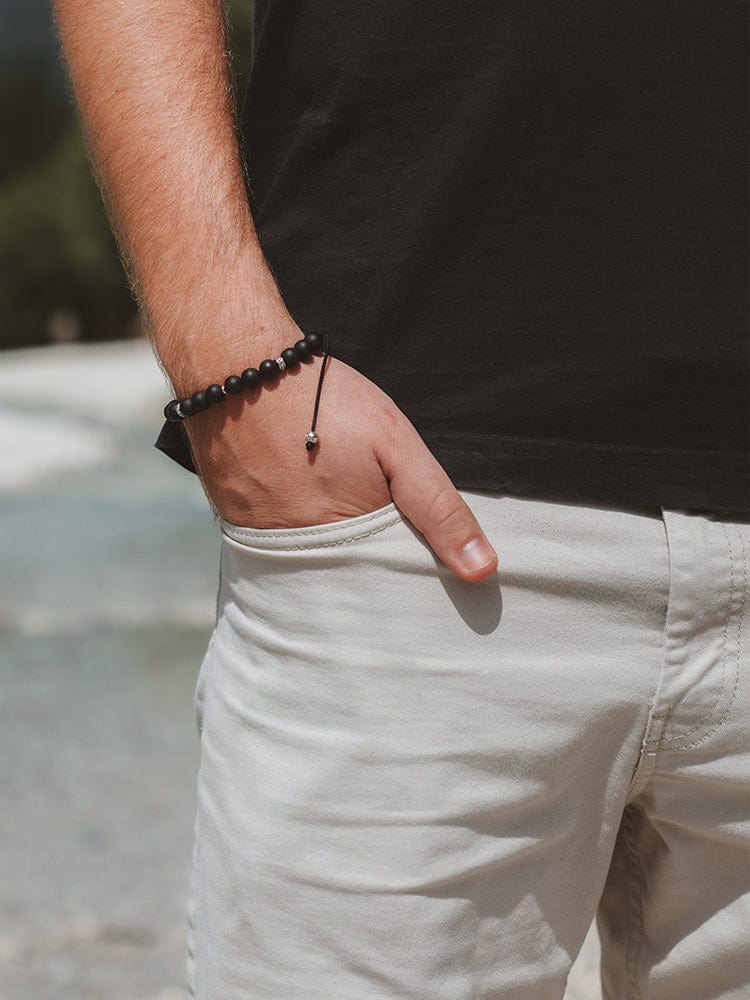 Black beaded bracelet on wrist with small round beads and simple cord adjustment
