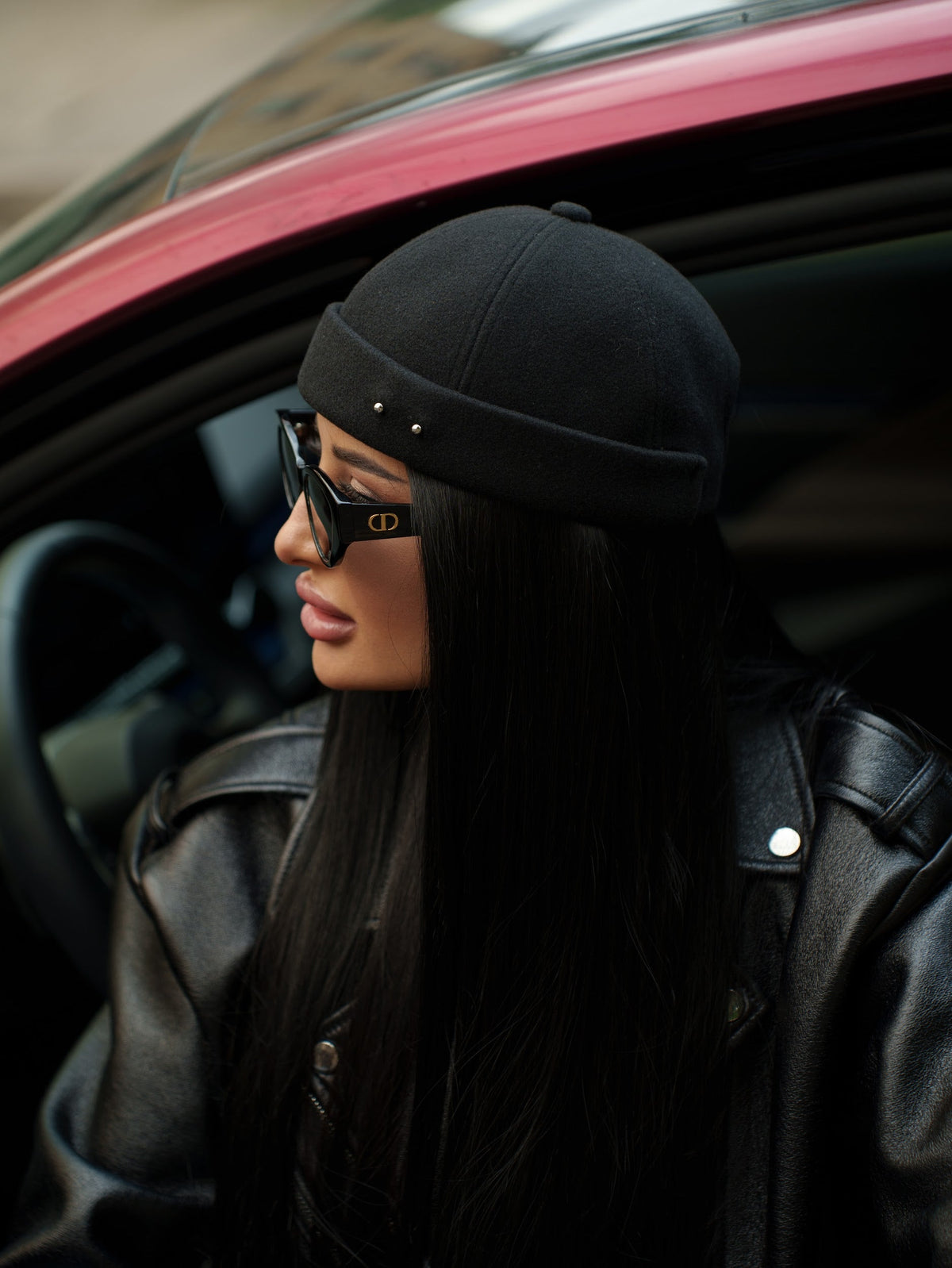 Black docker cap with metal eyelets and stud accents, side profile