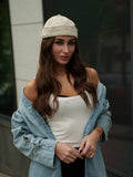 Beige canvas Docker-style cap with stitched panels and brown leather adjustment strap