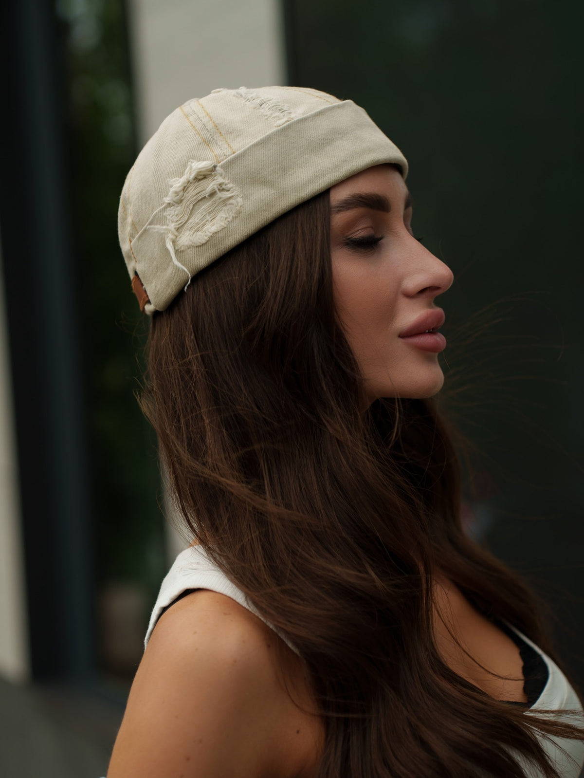 Sand denim docker cap on model, curved brim and stitched panels