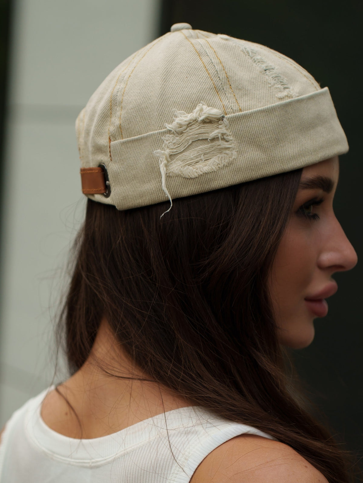 Beige canvas Docker-style cap with embroidered dragon patch and brown leather strap