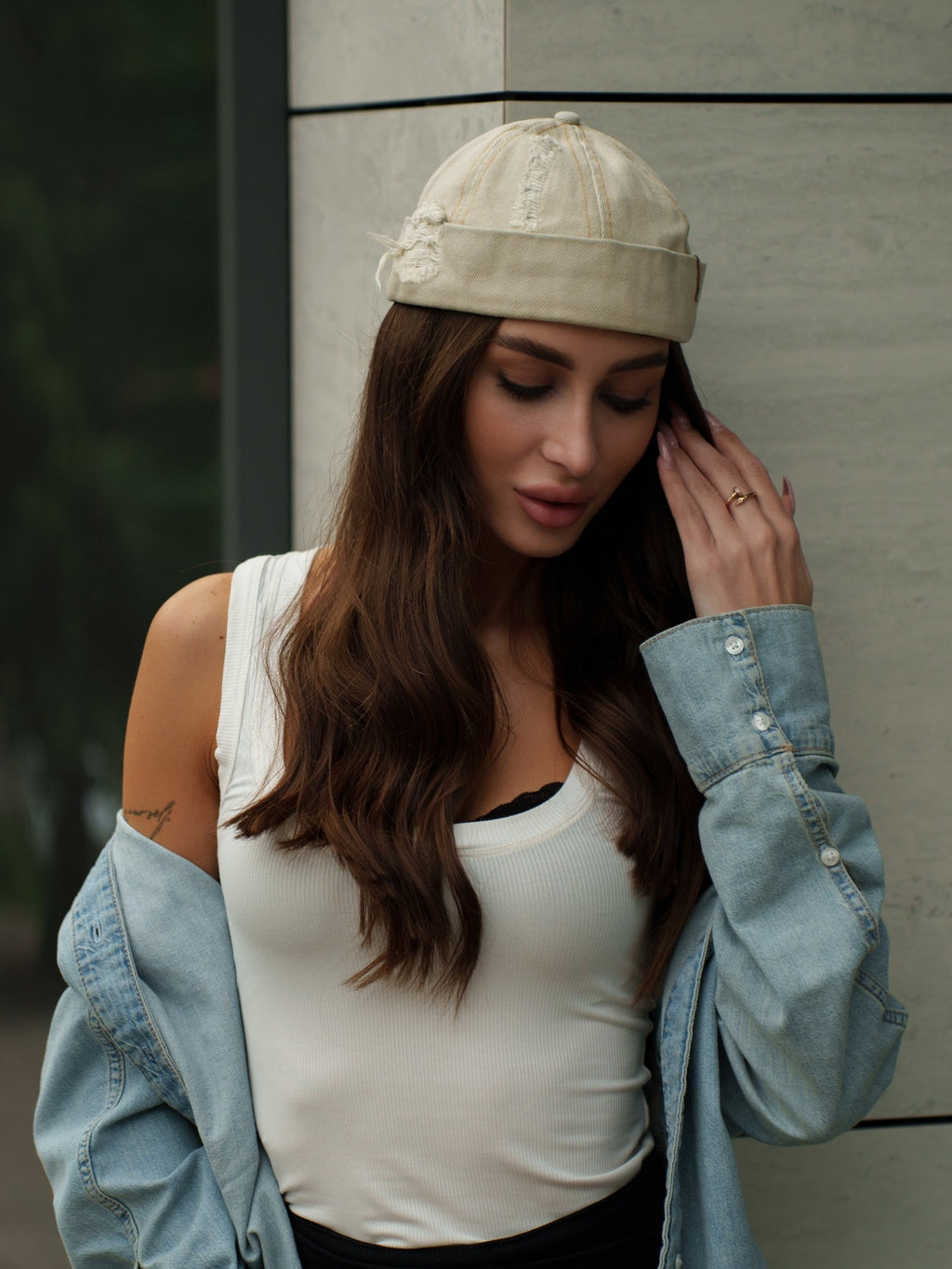 Beige canvas Docker-style cap on model with curved brim and stitched seams