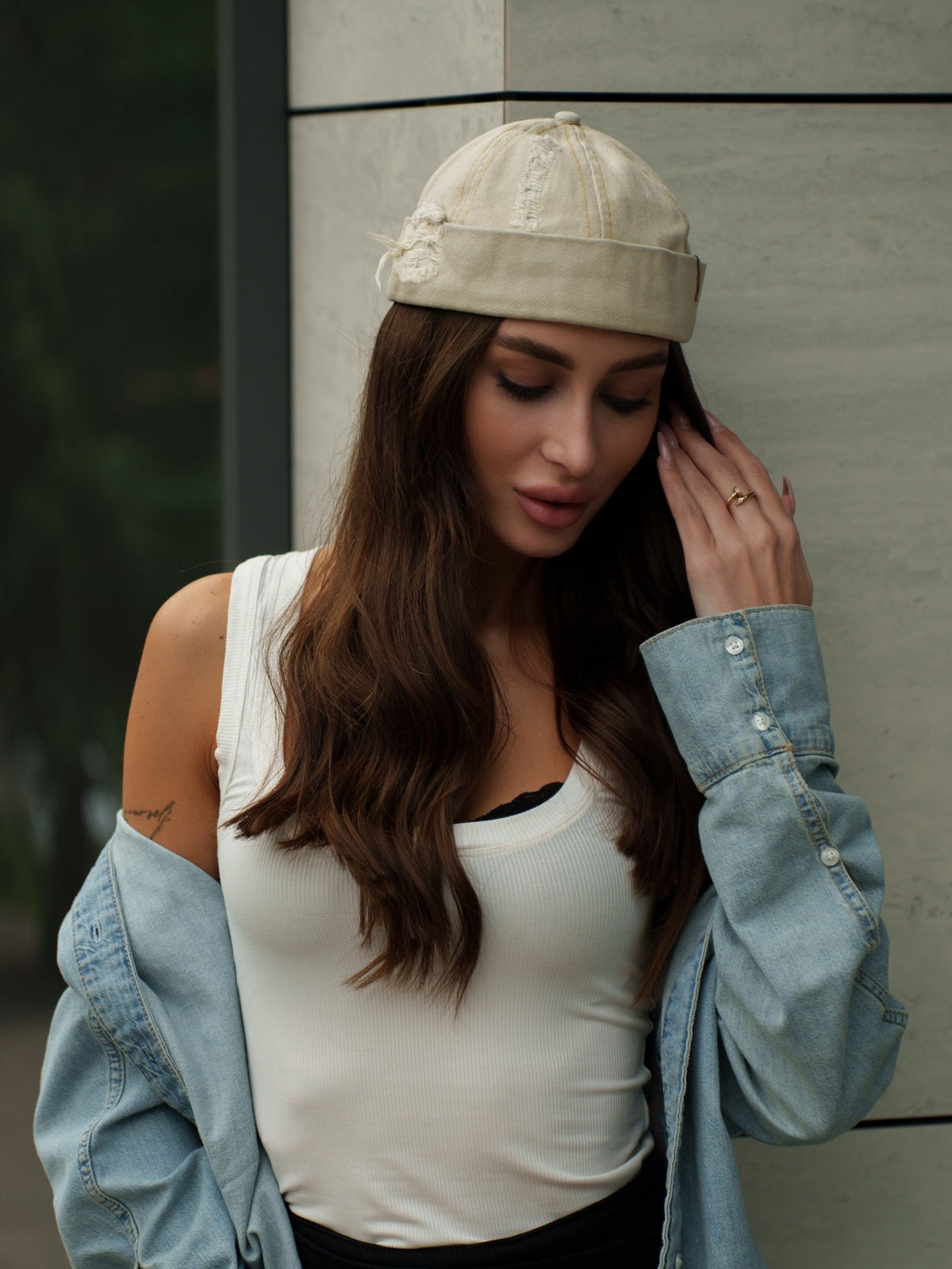 Beige canvas Docker-style cap on model with curved brim and stitched seams