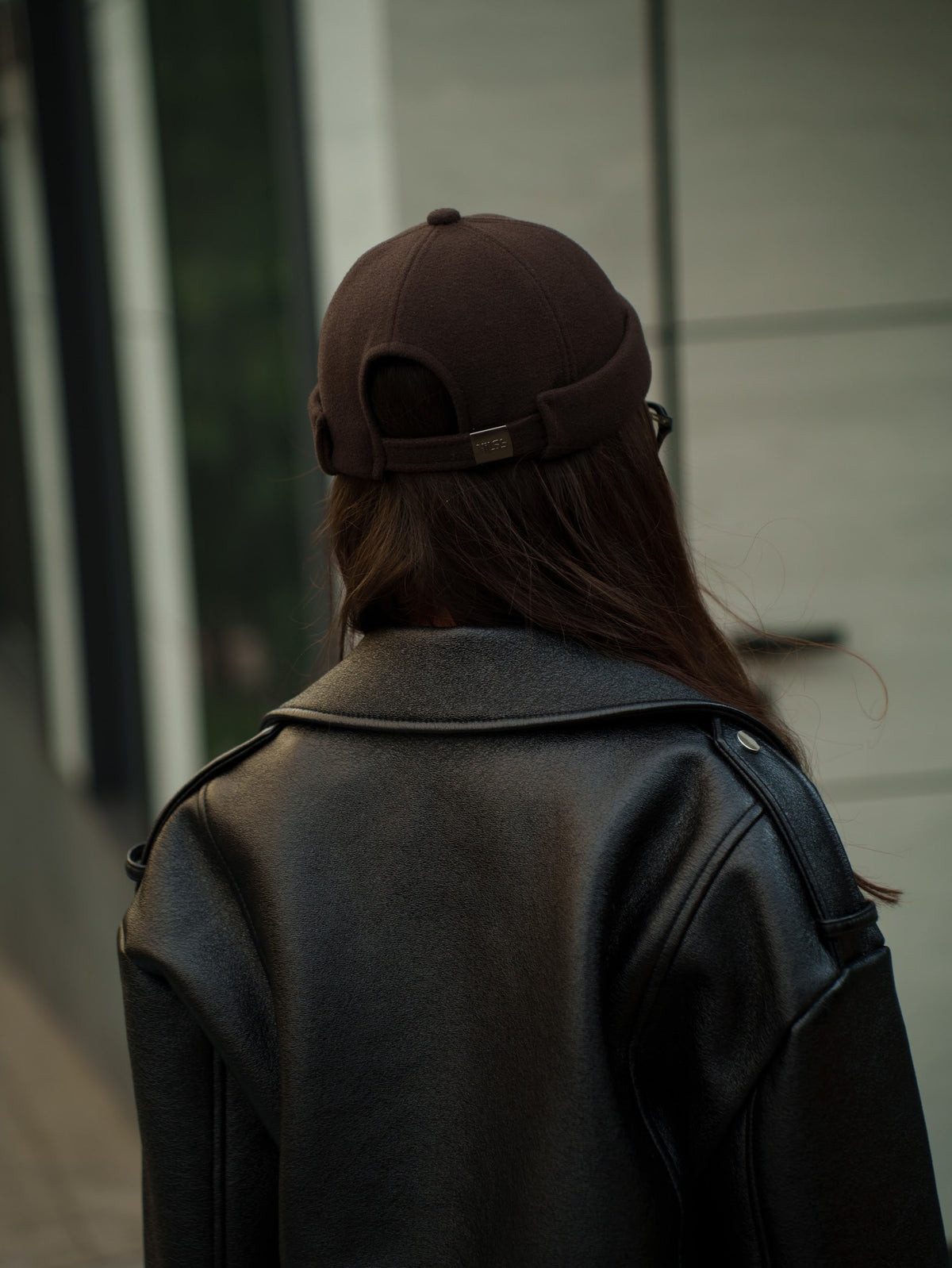 Dark brown felt docker cap with short brim and back strap detail