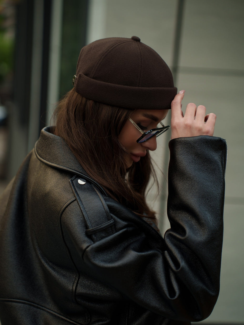 Dark brown docker cap worn with a low profile and stitched panel seams