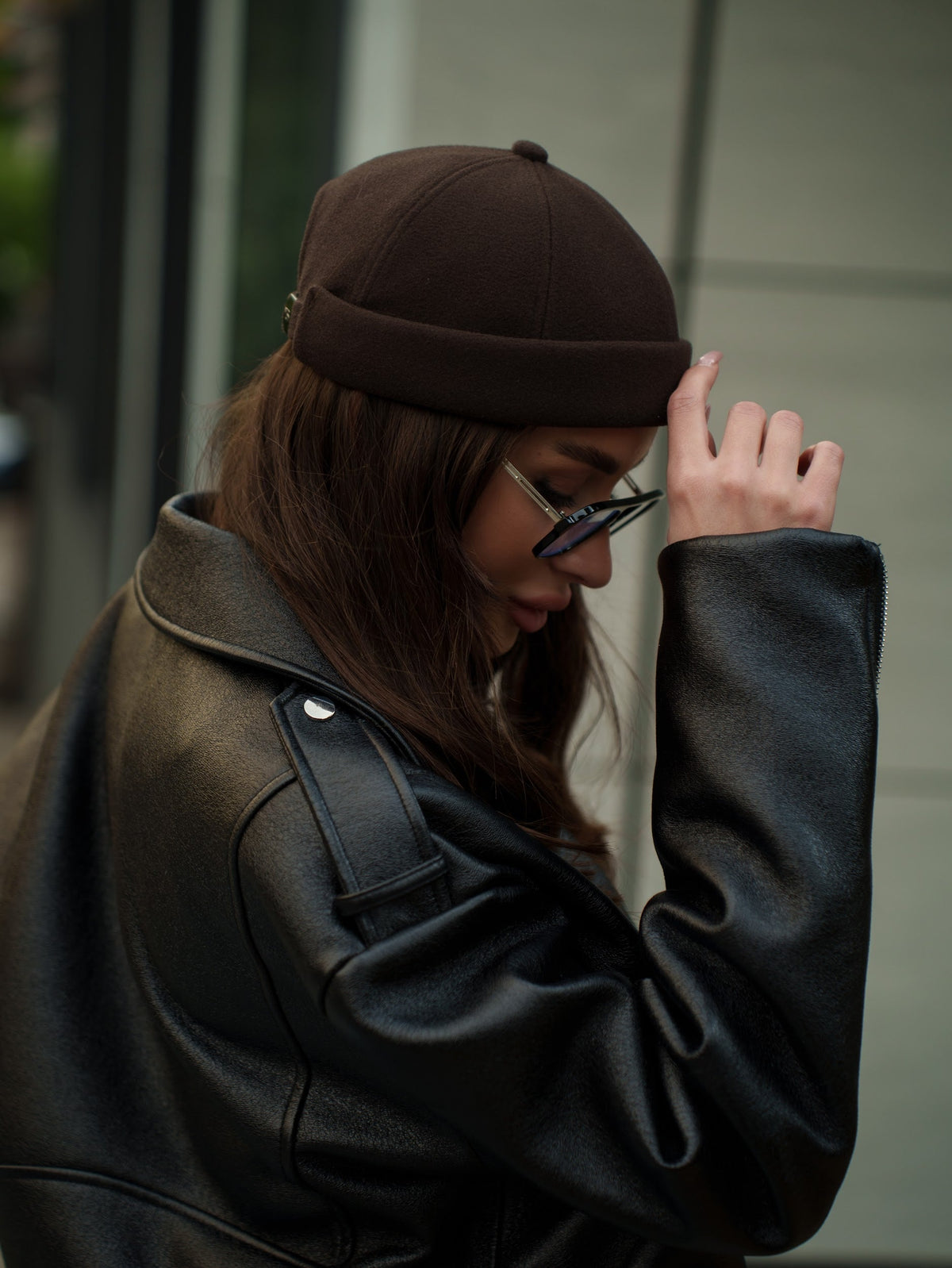 Dark brown docker cap worn with a low profile and stitched panel seams