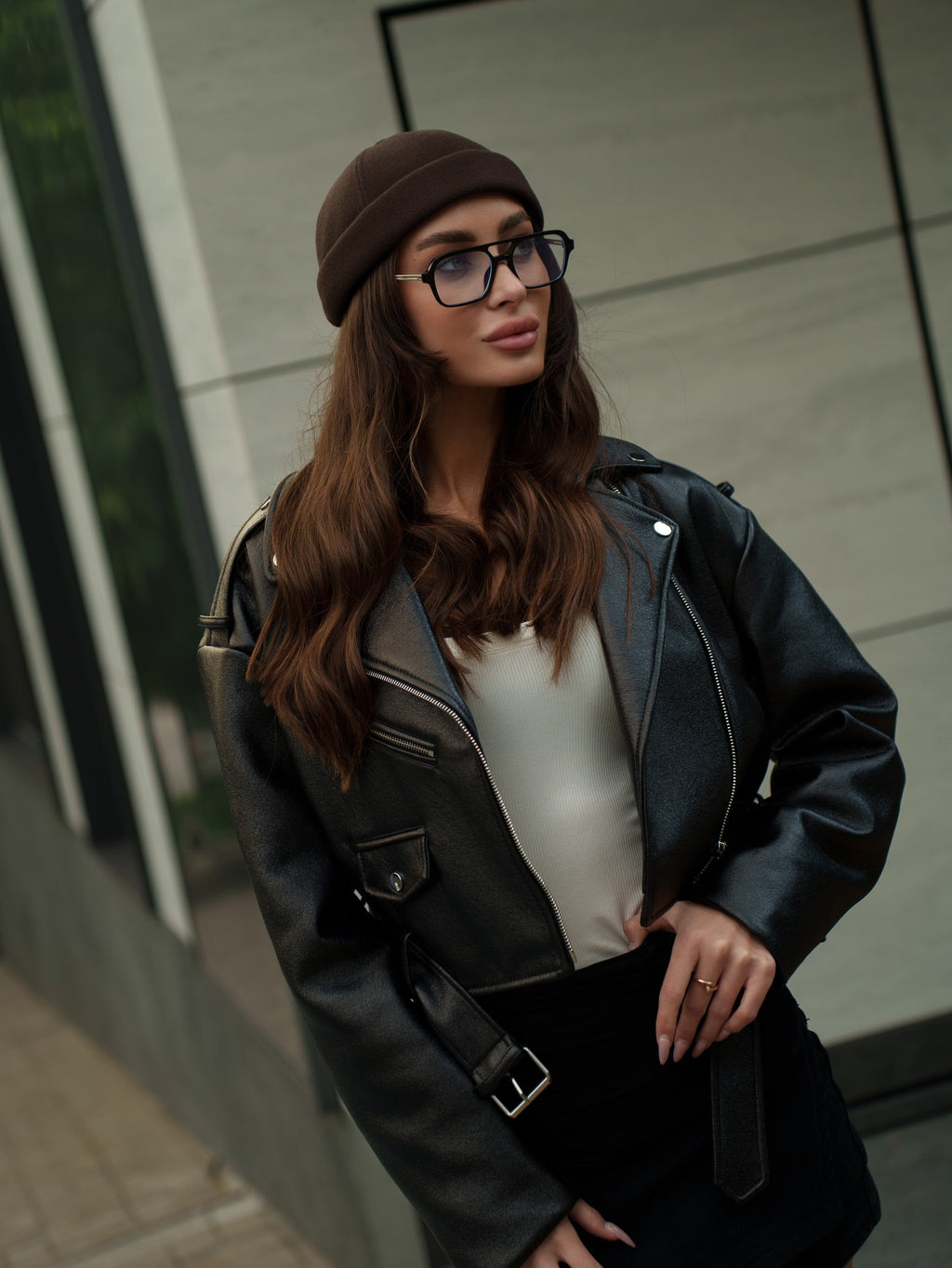 Dark brown felt docker cap with low crown, worn with glasses and a leather jacket