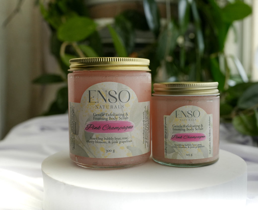 Gentle foaming sugar scrub jars with gold lids, two pastel-colored tubs on display