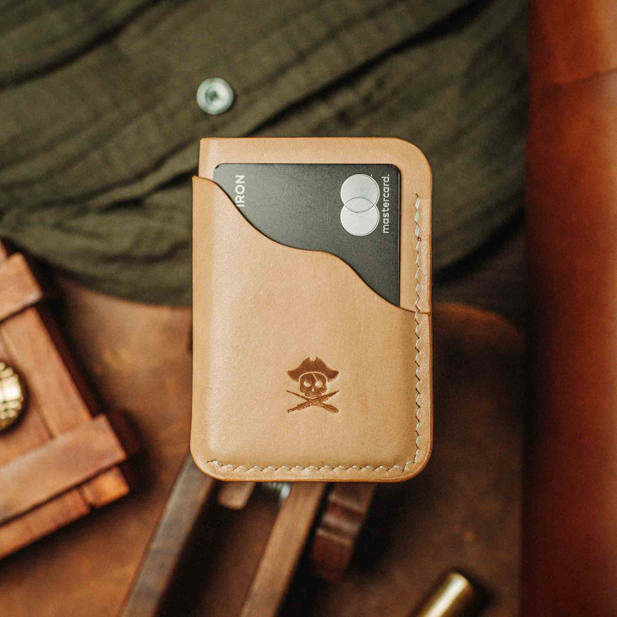 Light tan minimalist leather wallet with embossed logo and contrast edge stitching
