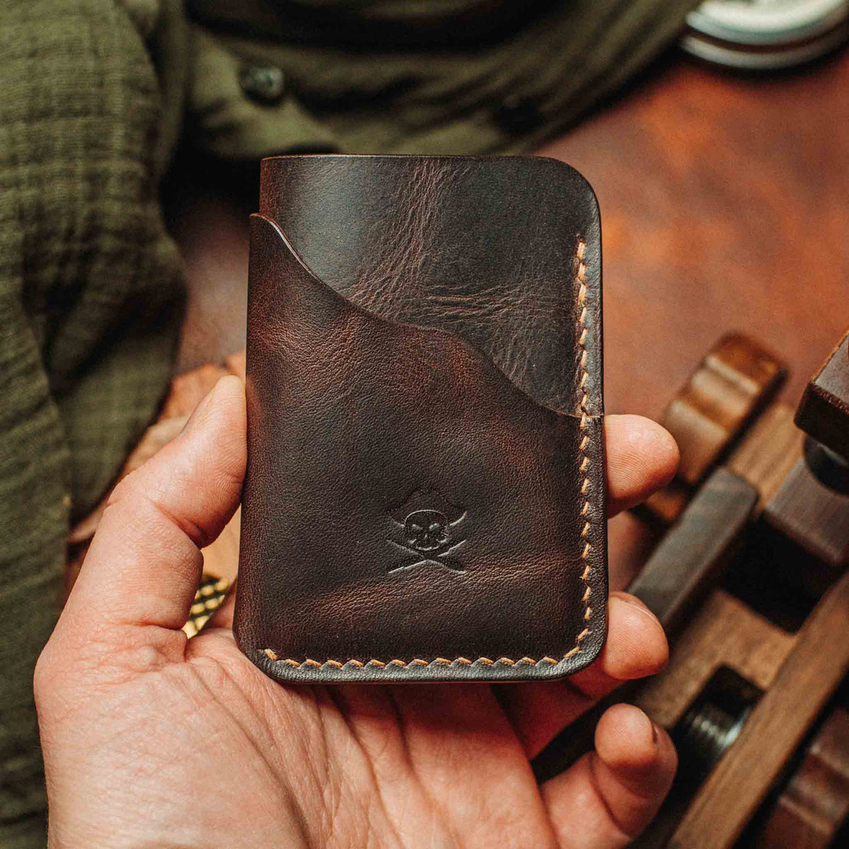 Dark brown minimalist leather wallet with embossed logo and contrast edge stitching