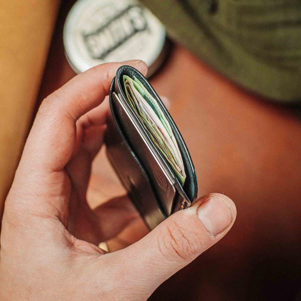 Minimalist leather wallet opened, showing multiple card slots and side profile stitching