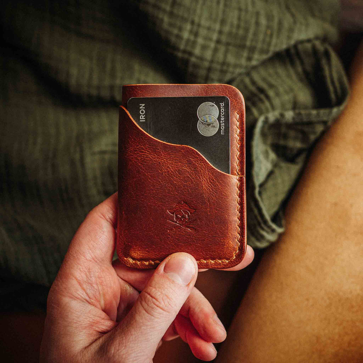 Red-brown minimalist leather wallet with embossed logo and stitched front panel