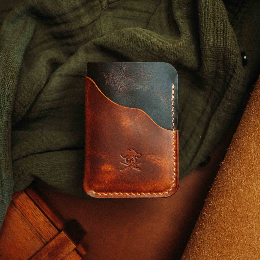 Brown minimalist leather wallet on fabric, front view with embossed logo and stitched edges