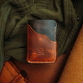 Brown minimalist leather wallet on fabric, front view with embossed logo and stitched edges