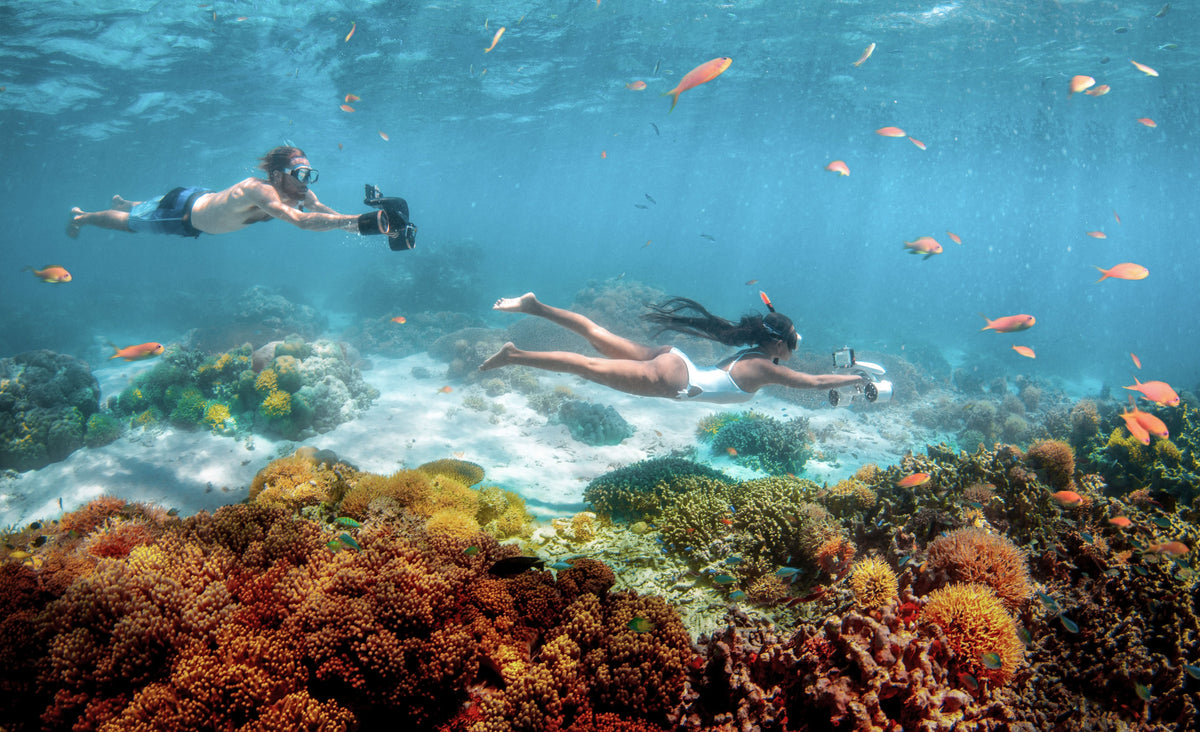 Scuba divers using underwater drones with camera modules underwater