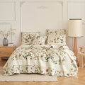 Floral quilt set in cream with beige rose, green leaves, and matching pillow shams