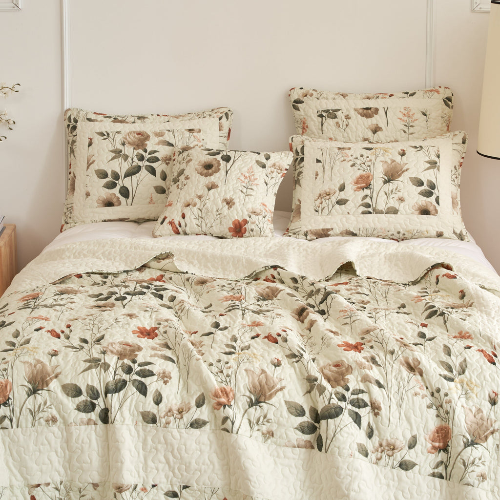 Cream floral quilt set with two pillow shams and quilted comforter with botanical motifs