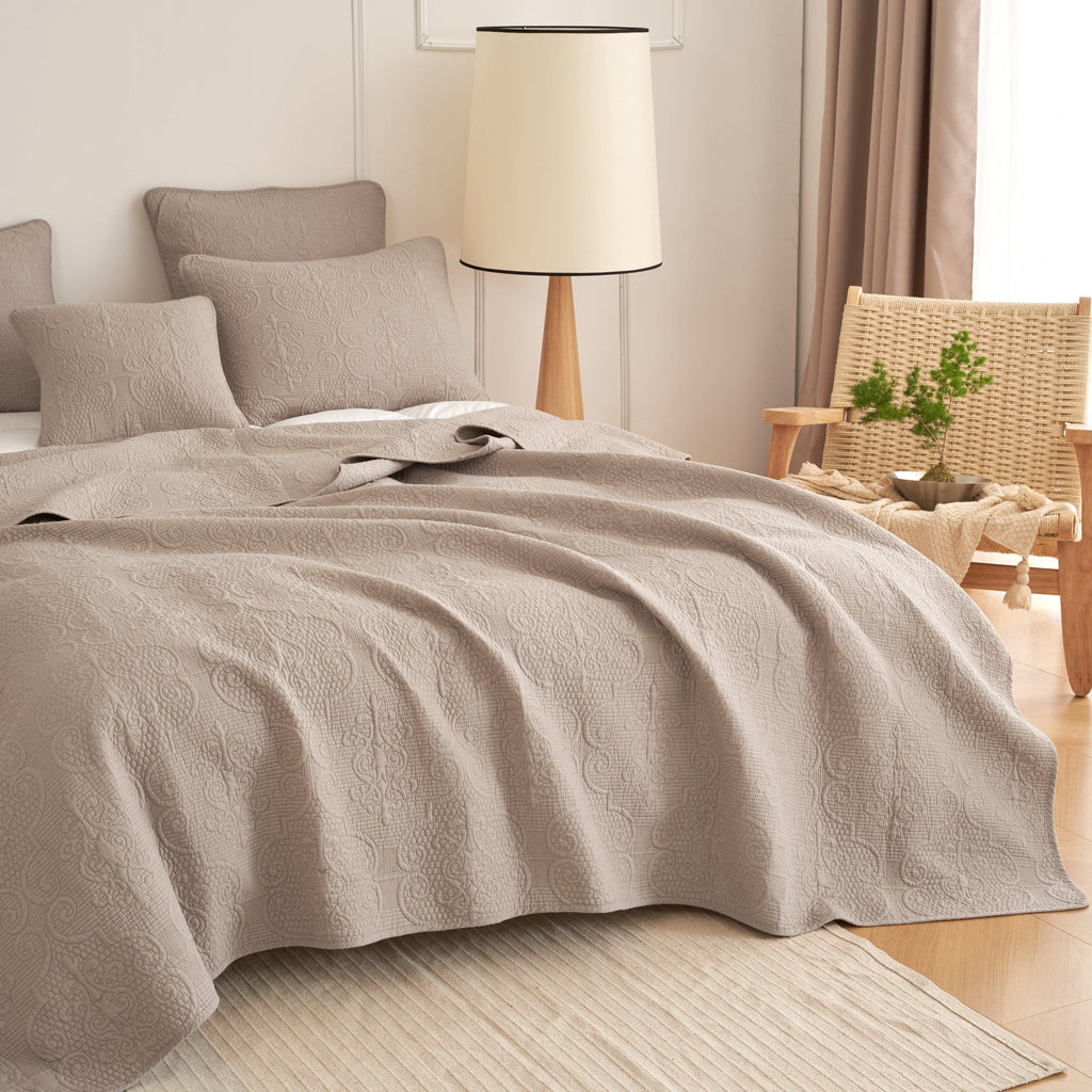 Taupe-beige quilted bedspread with textured stitching and matching pillows