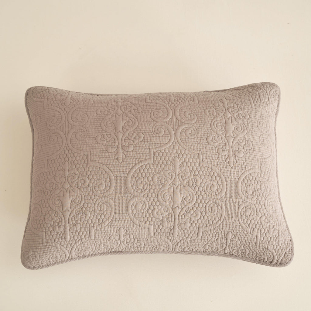Rectangular taupe-beige quilted pillow with ornate stitched scroll pattern