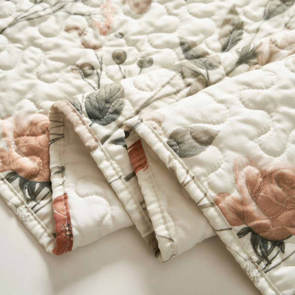 Quilted table runner hem and stitching detail, beige floral with rose and olive leaves