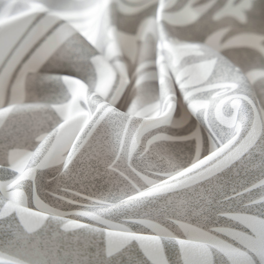 Gray and white ogee damask bed sheet fabric close-up