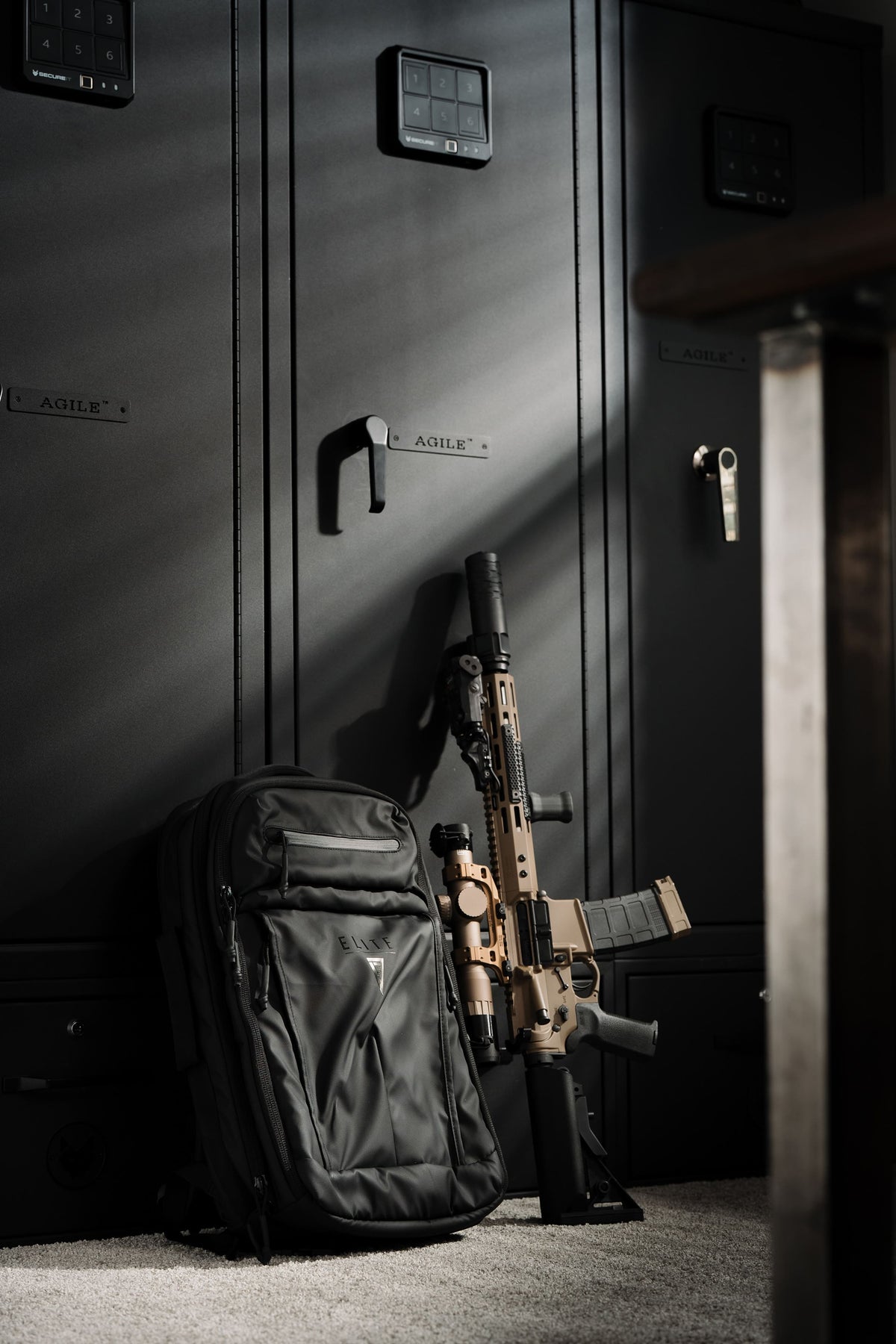 Dark backpack standing upright with front zip pocket and MOLLE-style straps