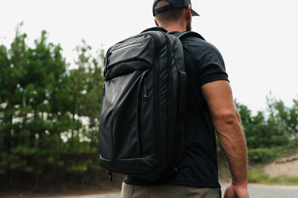SBR backpack on a person, dark color, padded back panel, and side zip pocket