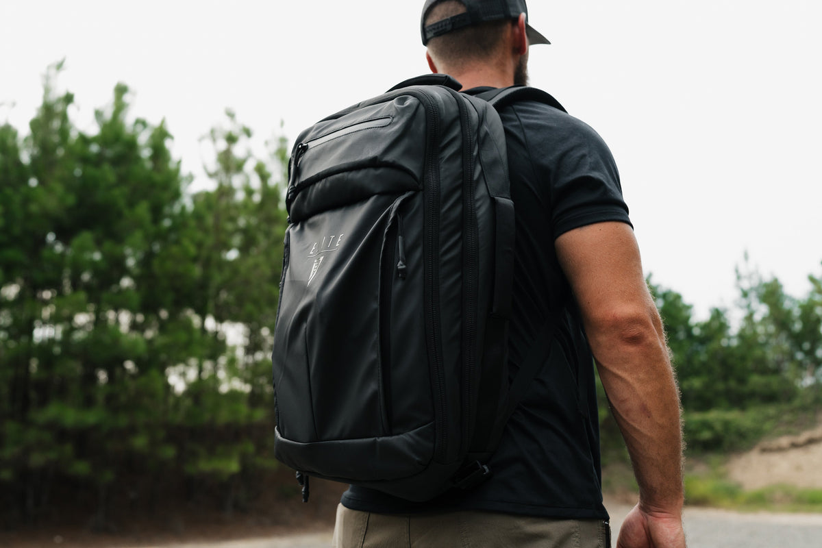 SBR backpack on a person, dark color, padded back panel, and side zip pocket
