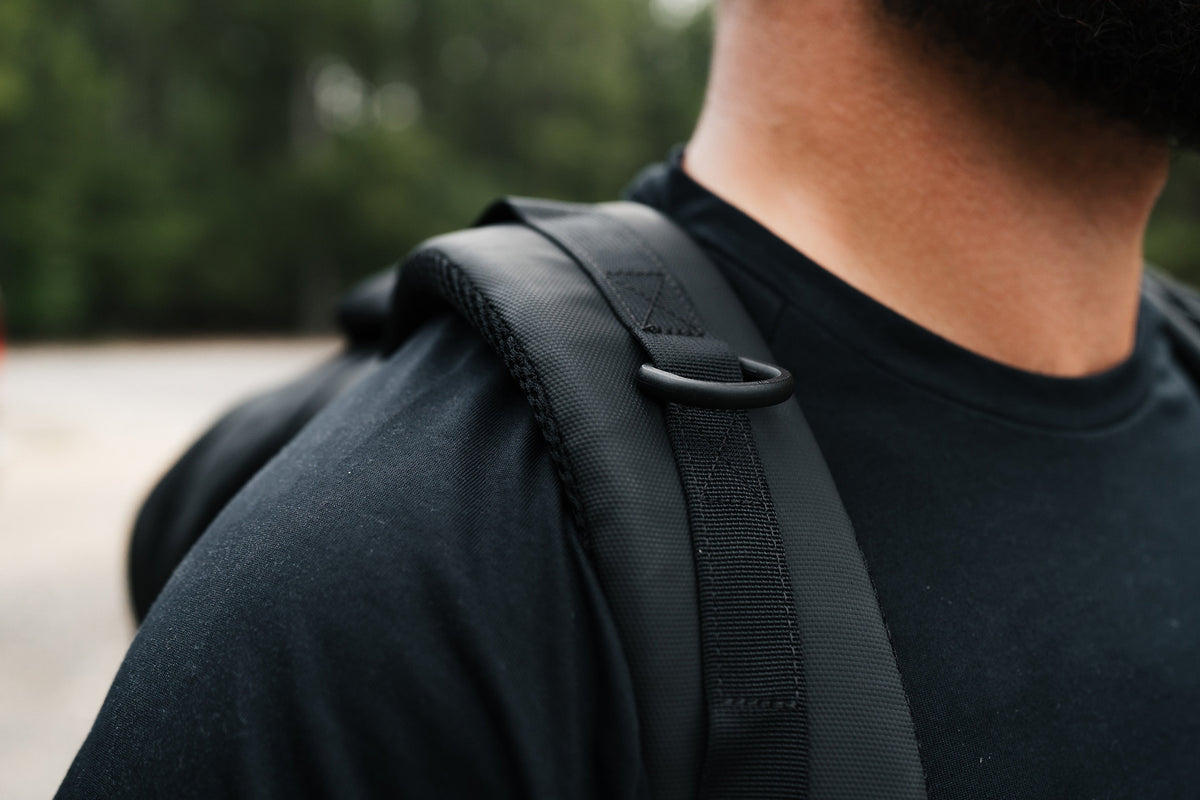 Close-up of dark backpack shoulder strap and textured fabric panel