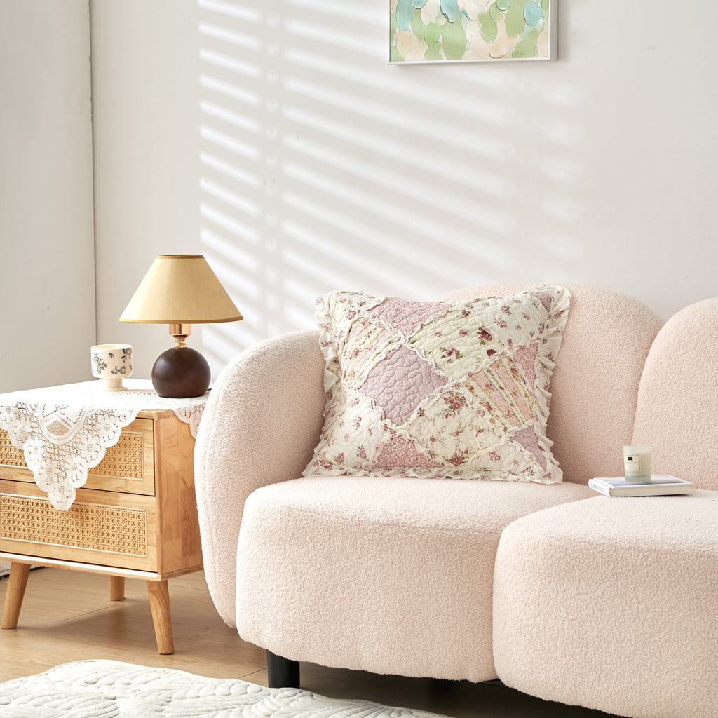 Floral quilted patchwork pillow cover in blush tones with decorative ruffle trim