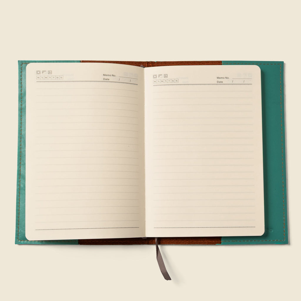 Teal leather notebook cover opened to lined pages with a gray pull tab.