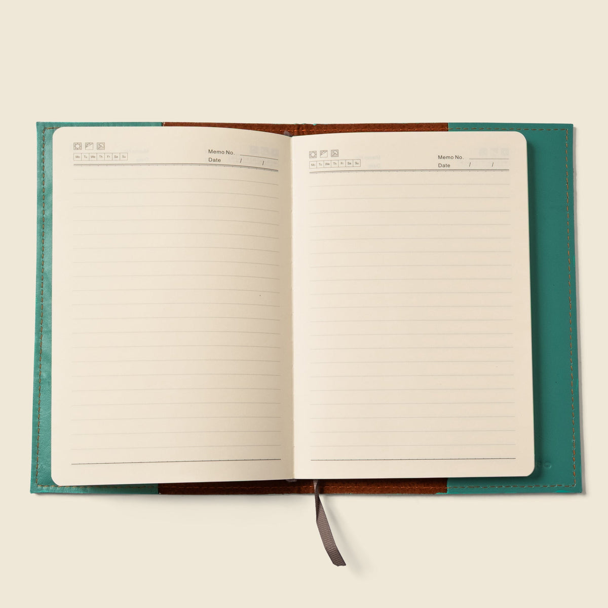 Teal leather notebook cover opened to lined pages with a gray pull tab.